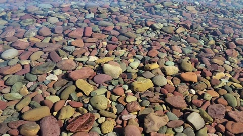 Super Clear Water Rippling over Smooth Colorful Stones Stock Footage 247794224