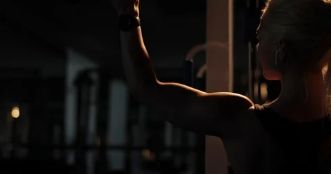 Super close-up, backlit rear view of a determined fitness lady pulling down the Stock Footage 123067447
