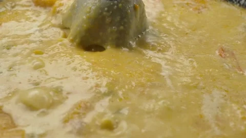 Super close-up of the blender mixing a pumpkin soup puree in pan in slow motion Stock Footage 234136813