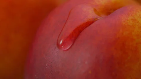 Super close-up of a drop of water flowing down the surface of a juicy peach Stock Footage 138223062