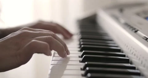 Super close up of female hands playing the piano. Woman touches fingers on keys Stock Footage 130784791