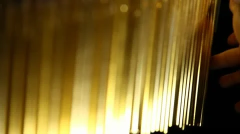 Super close up hand playing metallic gold chimes Stock Footage 21439843