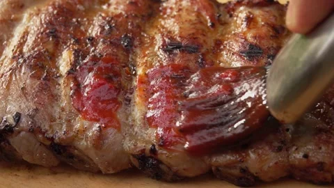 Super close-up of the kitchen brush smearing juicy spiced ribs with tomato sauce Stock Footage 169813811