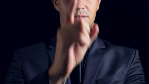 Super close-up of a man in black clothes on a black background. 4k. Slow motion Stock Footage 80003984