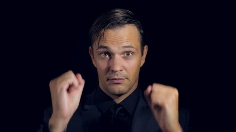 Super close-up of a man in black clothes on a black background. 4k. Slow motion Stock Footage 80004781