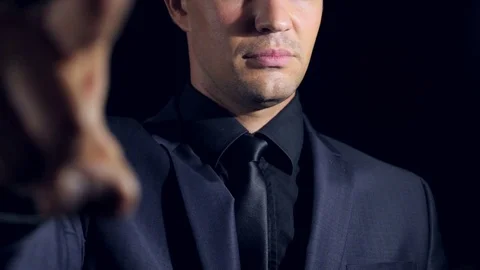 Super close-up of a man in black clothes on a black background. 4k. Slow motion Stock Footage 80041541