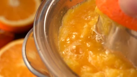Super close-up of the orange juice squizzed from the half of an orange Stock Footage 253872789