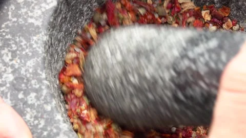 Super close-up of a pestle grinding and mixing various kinds of spices Stock Footage 294420452