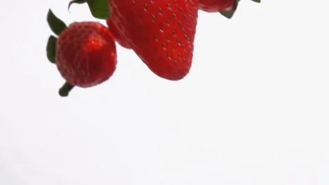 Super close-up of the red ripe strawberries falling down on the white background Stock-Footage 163934036