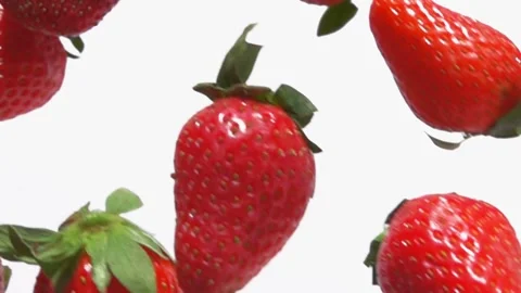 Super close-up of red strawberries flying and rotating on the white background Stock Footage 155413569