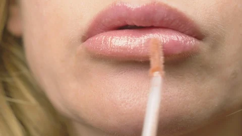 Super close-up, slow-motion, 4k. a woman is painting lips with lip gloss. lip Stock Footage 95726854