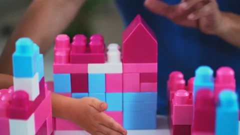 Super close up. Son and father playing bricks construction game on table in Stock Footage 132520232