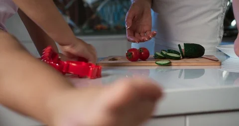 Super close-up view of kitchen counter top of a child playing with tomatoes as Stock Footage 123216236