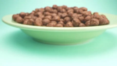 Super closeup. breakfast cereal in the form of chocolate corn balls on a plate Stock Footage 134938541