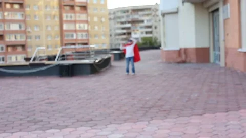 Super hero girl in the red cloak against the urban background Stock Footage