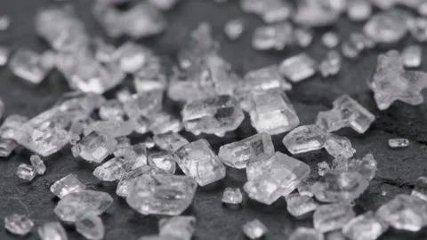 Super macro shot of white sugar crystals on black stone surface. Slider shot of Stock Footage 252284599