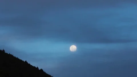 Super moon rising behind clouds 4K Stock Footage 85228855