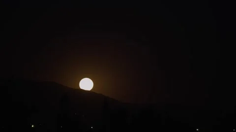 Super moon rising behind a mountain Stock Footage 241713305