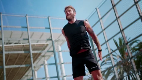 Super motivated muscular guy doing fast squatting workout outdoor at sunny Stock Footage 117130427