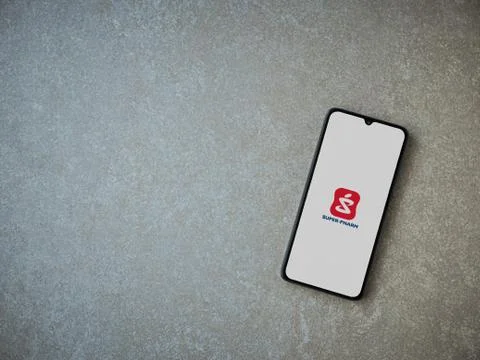 Super Pharm app launch screen with logo on the display of a black mobile smar Stock Photos