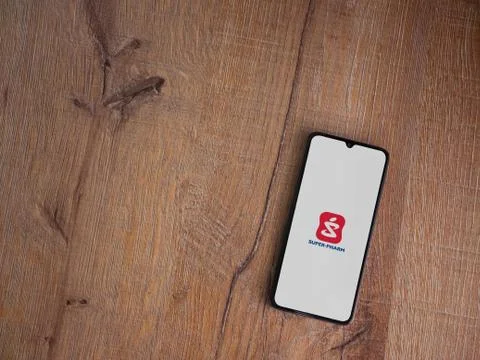 Super Pharm app launch screen with logo on the display of a black mobile smar Stock Photos