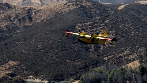 Super Scooper fire suppression water bomber aircraft at Castaic lake V24267 Stock Footage 94762688