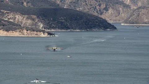 Super Scooper fire suppression water bomber aircraft at Castaic lake V24265 Stock Footage 94762816