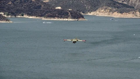 Super Scooper fire suppression water bomber aircraft at Castaic lake V24266 Video stock 94762942