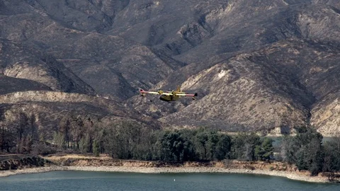 Super Scooper fire suppression water bomber aircraft at Castaic lake V24268 Stock Footage 94763173