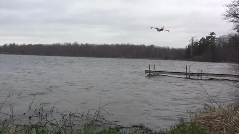 Super Scooper firefighting plane scoops water from lake Stock-Footage 298035257