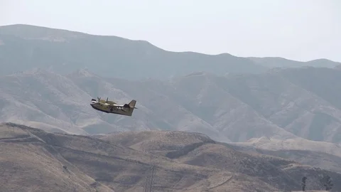 Super scooper long slow motion climbout in mountainous terrain Stock Footage 79862047