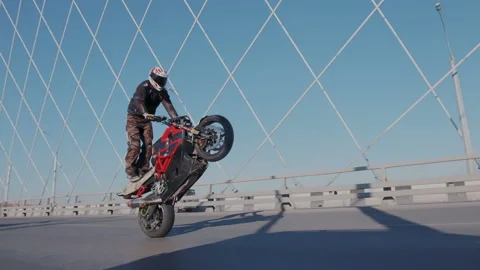 Super skilled motorcyclist riding on the rear wheel of his sport motorcycle and Stock Footage 105013053