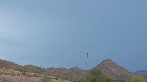 Super slomo daytime lightning strikes over desert hills Stock Footage