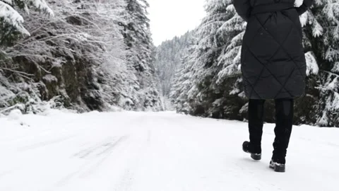 Super slow motion 240 frames of a girl walking on a snowy road in the winter Video stock 189522380