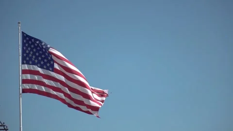 SUPER SLOW MOTION: American Flag blowing in the wind with a blue sky background Stock Footage 254545167