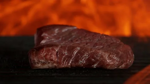 Super slow motion of beef steak falling on grill with fire on black background Stock Footage 146006391