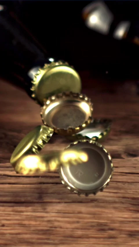 Super slow motion beer lids fall on the table and rotate. Filmed on a high-speed Stock Footage 335288206