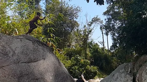 Super slow motion of a boy jumping from a rock. Stock Footage 115332267