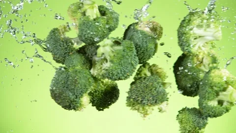 Super slow motion of broccoli pieces flying up in the air with water splashes. Stock Footage 137161162