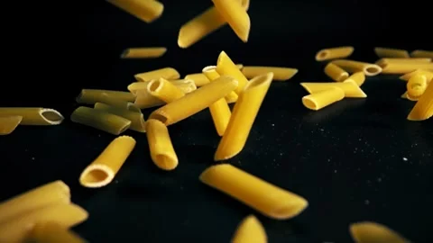 Super Slow Motion Capture of Raw Italian Penne Pasta Tumbling Against a Black Stock Footage 272189617