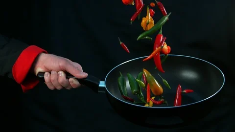 Super slow motion of chef holding frying with falling chilli peppers Stock Footage 117845018