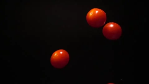 Super slow motion of cherry tomatoes flying into the air with a splash of water. Vídeo Stock 252406126