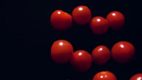 Super slow motion of cherry tomatoes flying on a black background in slow motion Stock-Footage 252406159