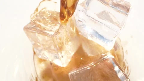 Super slow motion close up of pouring cola into a drinking glass with ice cubes Stock Footage 153806822
