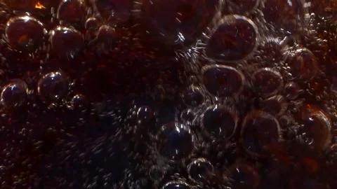 Super slow motion closeup of cola drink splashing with bubbles, drops and foam Stockbeeldmateriaal 155473387