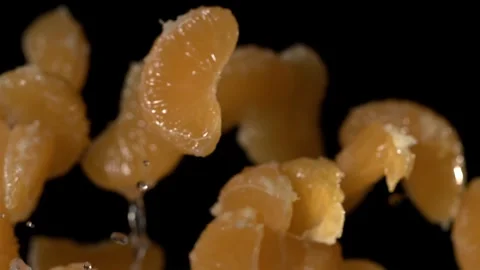 Super slow motion Closeup of mandarin slices spilling juice against shadowed Stock Footage 326276279