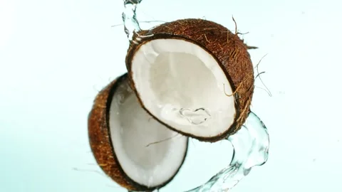 Super Slow Motion of Coconut Pieces Flying in the Air with Water Splashes. Stock Footage 247693278