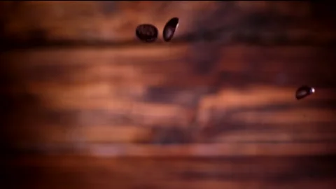 Super slow motion coffee beans falling on a wooden background 1000 fps Stock Footage 130972595