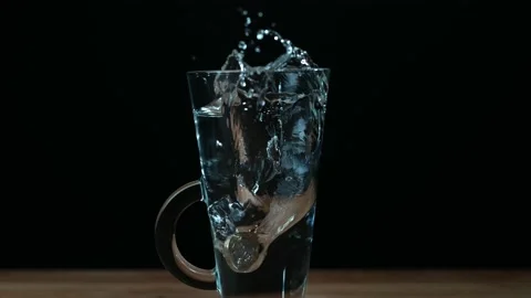 Super Slow Motion Coin Falling into Glass of Water on Table Video stock 200787724