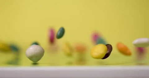 Super Slow Motion Colorful Candy Pieces Bouncing On Yellow  Stock Footage 333485185